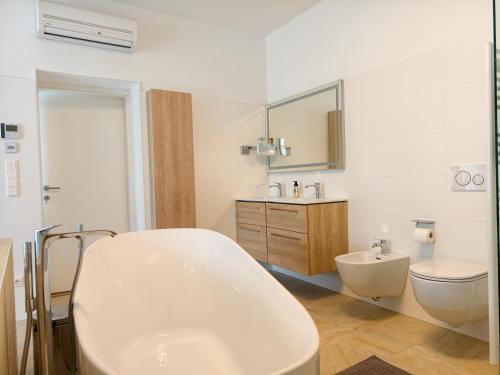 a bathroom with a tub and a toilet and a sink at Ferienwohnung EPIKUR in Payerbach