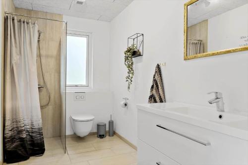 a white bathroom with a toilet and a sink at LF14143-Spottrup-Basaltvej-1 in Spottrup