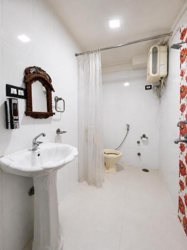 a white bathroom with a sink and a toilet at Whereabout Hostel Udaipur in Udaipur