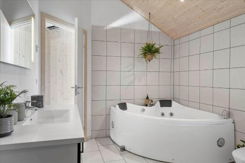 a white bathroom with a tub and a sink at LF15028-Skals-Lynderup-Strand-6 in Skals