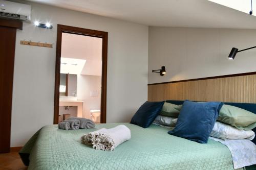 a bedroom with a large green bed with blue pillows at Centro mare residence affitta alloggi in Porto Torres