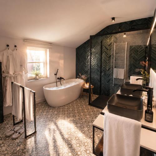 a large bathroom with a tub and a sink at Cha Cha de Loup-B&B-Vakantiewoning met verwarmd binnenzwembad en groot zonneterras in de Ardennen in Rendeux