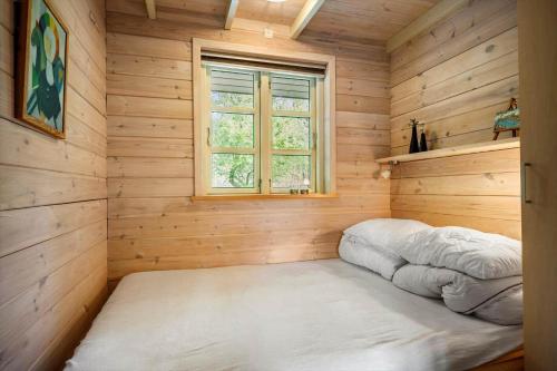 a bedroom with a bed in a wooden room with a window at LF15023-Skals-Lynderup-Strand-2 in Skals