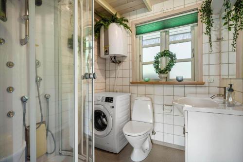 a bathroom with a toilet a sink and a washing machine at LF15023-Skals-Lynderup-Strand-2 in Skals