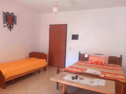 a small room with two beds and a table at Appartamento lungomare Bianca in Vlorë