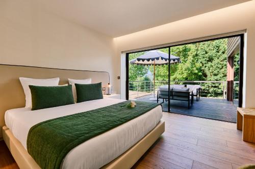 a bedroom with a bed and a balcony with a table at Hotel Aquafalls in Caniçada