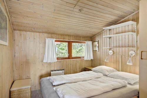 two beds in a room with wooden walls at LF18110-Veslos-Agerovej-13 in Vesløs