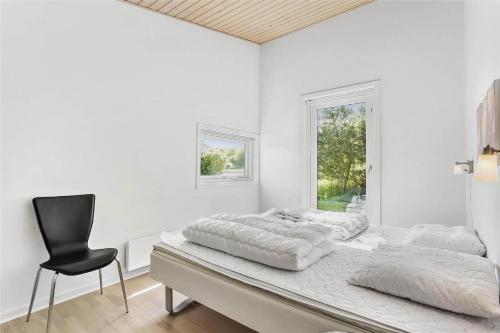 a white bedroom with two beds and a chair at LF530-Vestervig-Hannesvej-30 in Vestervig