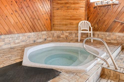 a jacuzzi tub with a chair in a room at Days Inn by Wyndham Columbia Mall in Grand Forks