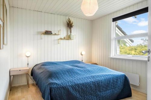a bedroom with a blue bed and a window at 393-Harboore-Fourmivej-10 in Harboør
