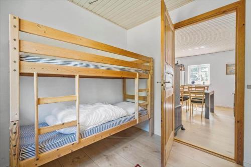 a bedroom with bunk beds and a dining room at 0007-Romo-Juvrevej-37 in Høm