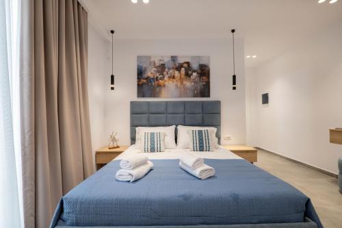 a bedroom with a blue bed with towels on it at Vila Antonio in Ksamil