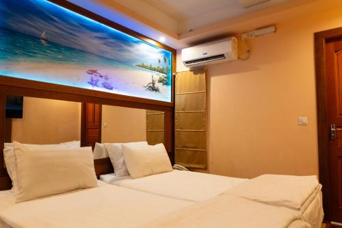 a hotel room with two beds and a tv on the wall at Six In Lodge in Male City