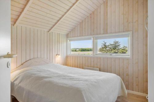 a bedroom with a white bed and a window at LF10209-Thyholm-Markvejen-9 in Thyholm