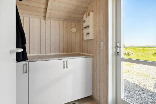 a kitchen with white cabinets and a window at LF10209-Thyholm-Markvejen-9 in Thyholm