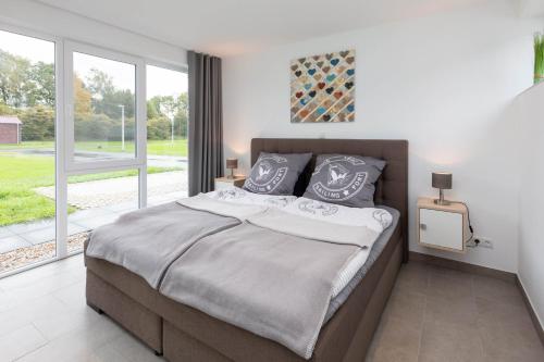 a bedroom with a large bed and a large window at Haus 21 am See in Schüttorf