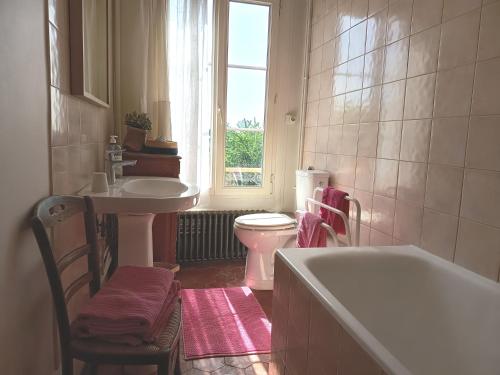 a bathroom with a tub and a sink and a toilet at Clos Florésine B&B in Venette