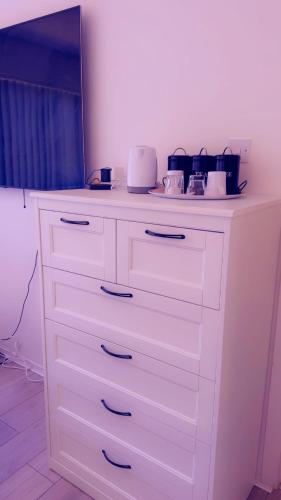a white dresser in a room with a counter at 32 Hatton Guest House in Milton Keynes