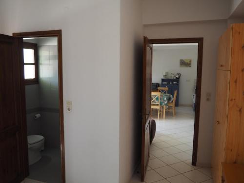 a hallway with a toilet and a dining room at Genos suites in Stavros