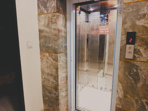 a glass elevator in a room with a stone wall at Hotel Shree krishna in Ujjain