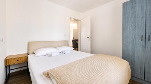 a bedroom with a large white bed with a wooden table at Danube Panorama House - River View, Jacuzzi & Nature in Čelarevo