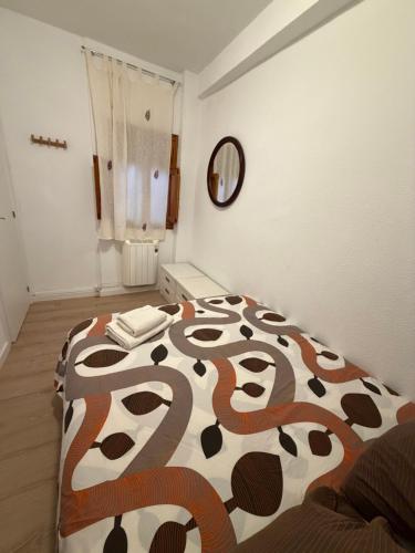 a bedroom with a bed with a brown and white comforter at Casa Emilia in Talayuelas