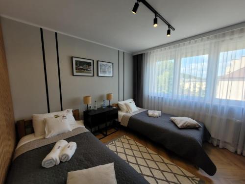 a bedroom with two beds and a window at Apartament Skansen - Sanok in Sanok