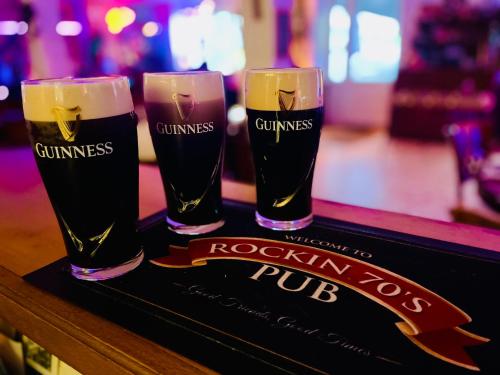 three glasses of beer sitting on a bar at Rockin 70's Lodges in Barbey-Séroux