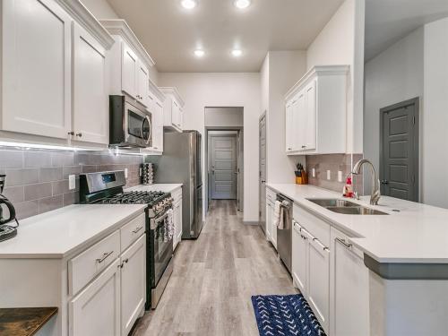a kitchen with white cabinets and a refrigerator at Your Unforgettable Temporary Haven! in Edmond