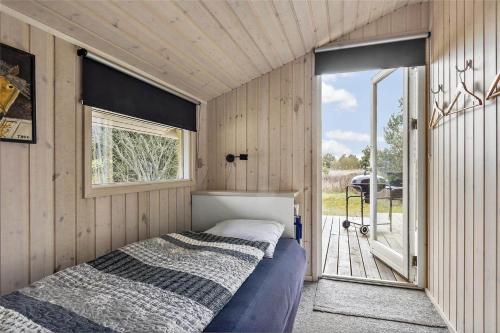 a bed in a small room with a window at 0143-Romo-Ejnar-Mikkelsensvej-11 in Høm