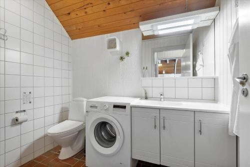 a bathroom with a washing machine and a toilet at 0273-Romo-Lyngvejen-63-B in Høm