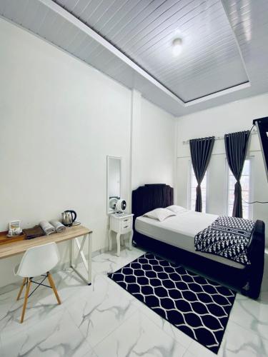 a bedroom with a bed and a desk and a chair at Detara Homestay Syariah in Takengon
