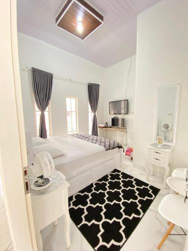 a bedroom with a bed and a black and white rug at Detara Homestay Syariah in Takengon