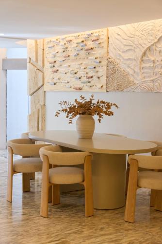 a table and chairs with a vase on top of it at Suites ROC Portonova - Newly Renovated 2026 in Palmanova