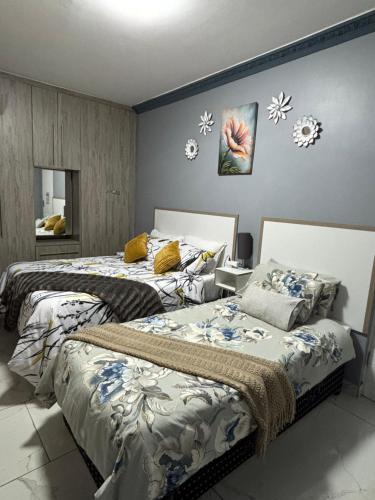 two beds sitting next to each other in a bedroom at Sunset Villa 786 Overport in Durban