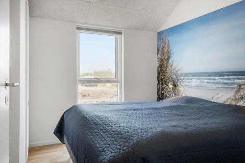 a bedroom with a bed with a view of the ocean at 394-Harboore-Hermodsvej-8 in Harboør