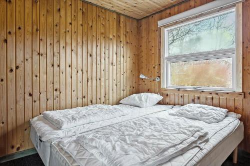a bed in a wooden room with a window at LF14092-Roslev-Eskovvej-92 in Roslev