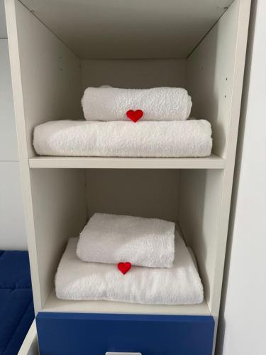 a shelf with towels and two red hearts on them at Eleven Home in Bari