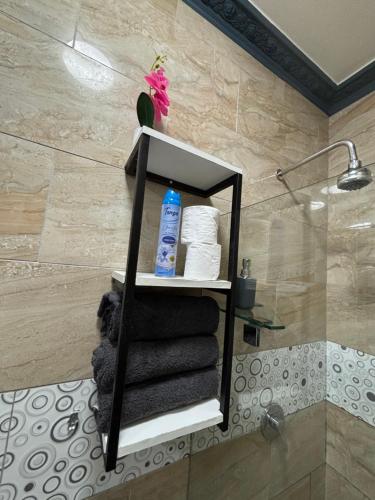a bathroom with a shelf with towels and a shower at Sunset Villa 786 Overport in Durban