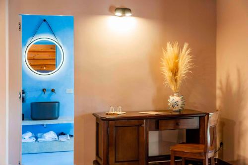 ein Esszimmer mit einem Tisch und einem Spiegel in der Unterkunft Feudo Bauly in Palazzolo Acreide