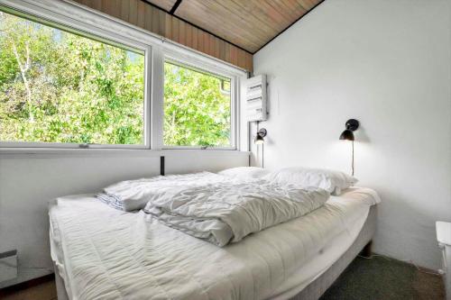 a bedroom with a white bed with a window at 18008-Holbaek-Raevestien-5 in Holbæk