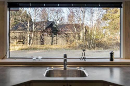 a kitchen sink with a view of a house through a window at 0259-Romo-Lyngvejen-89-B in Høm