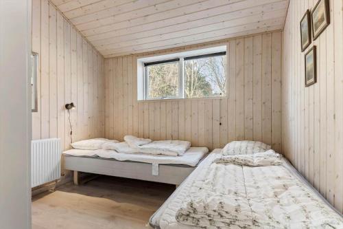 two beds in a room with a window at 0259-Romo-Lyngvejen-89-B in Høm