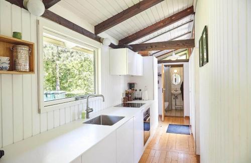a kitchen with white counters and a window and a sink at 13405-1-Hojby-Avaenget-1 in Højby