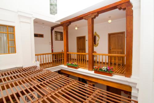 a balcony with a wooden bench and flowers on it at Casa Hotel Las Plazas in Quito