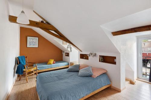 a bedroom with a blue bed and a chair at Dordinaire Maison D'hôtes in Nouans-les-Fontaines