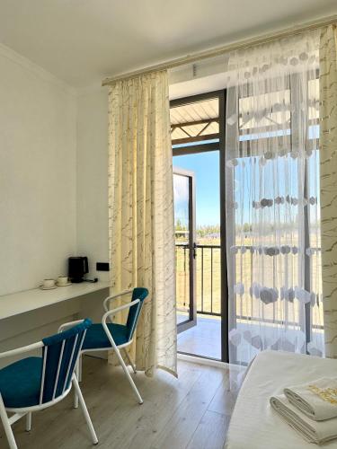 a bedroom with a desk and two chairs and a table at Өркүндө in Chon-Sary-Oy