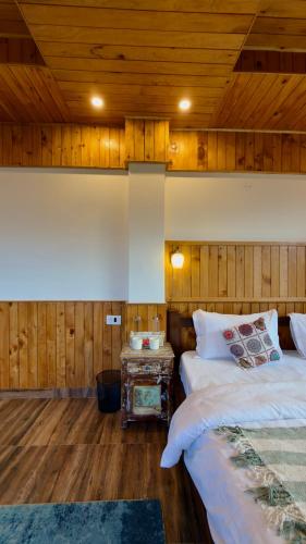 a bedroom with two beds and a wooden ceiling at Almost Home in Shangarh