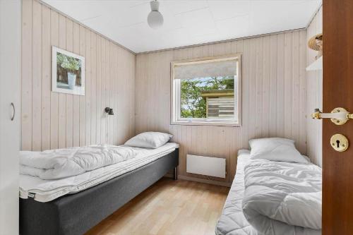 two beds in a room with a window at LF16084-Farso-Kjeldhoj-84 in Farsø