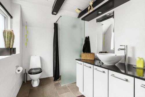 a white bathroom with a sink and a toilet at LF15103-Farso-Rorsangervej-3 in Farsø
